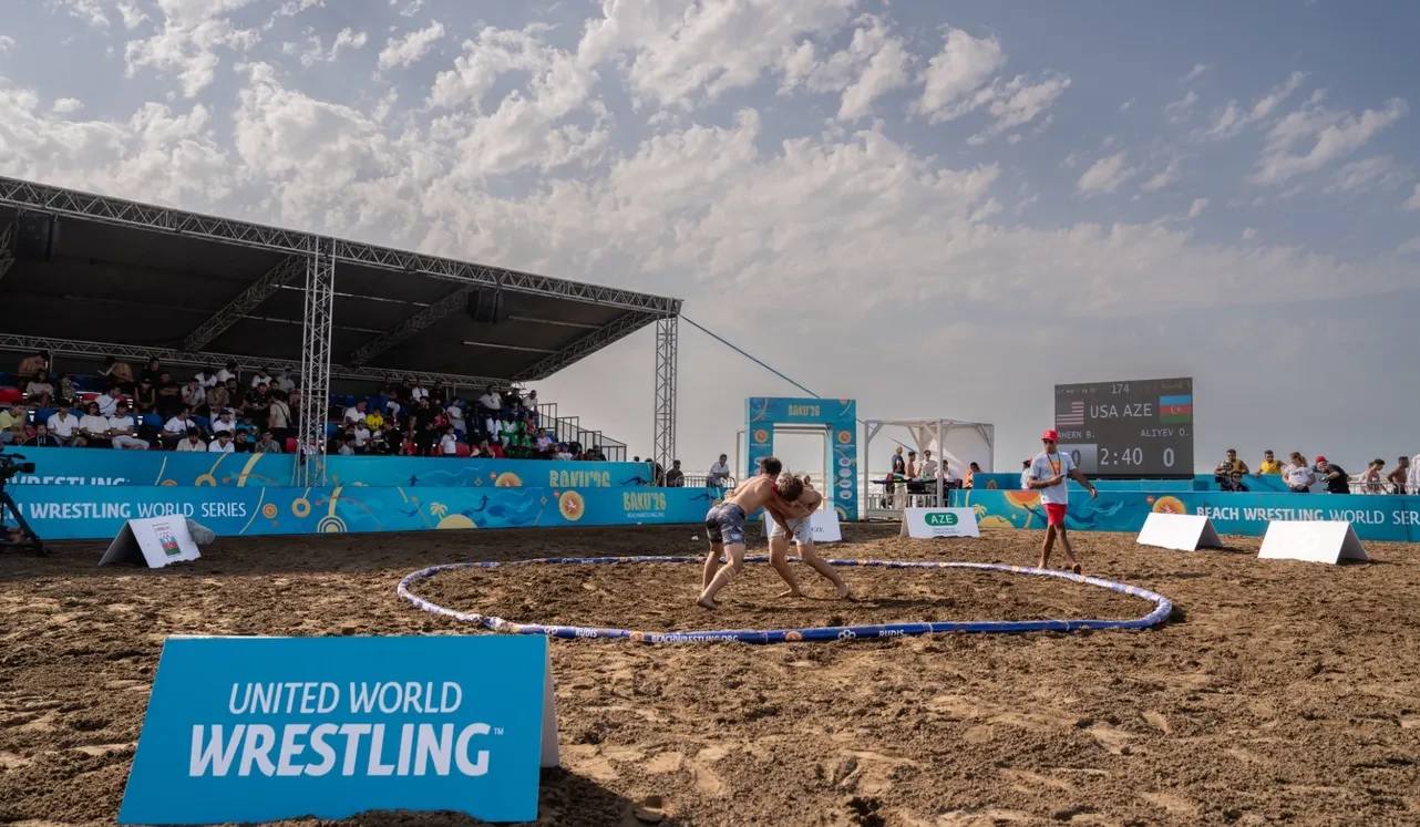 Qumda çimərlik güləşi üçün dairə, tribunalar və United World Wrestling tablosu